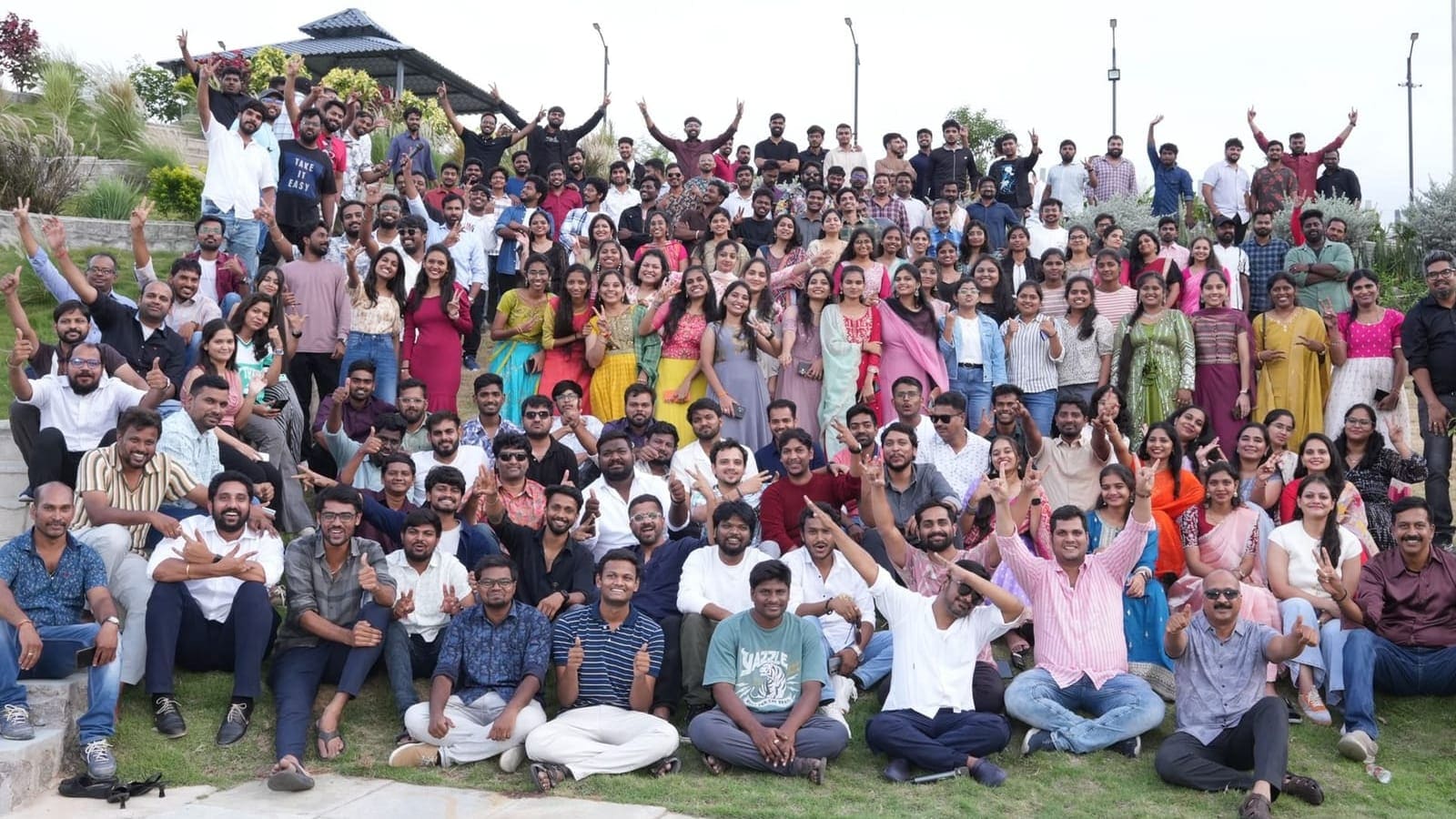 The whole Praval team on the terraced lawn at the annual plenary, with the pavilion and light poles behind